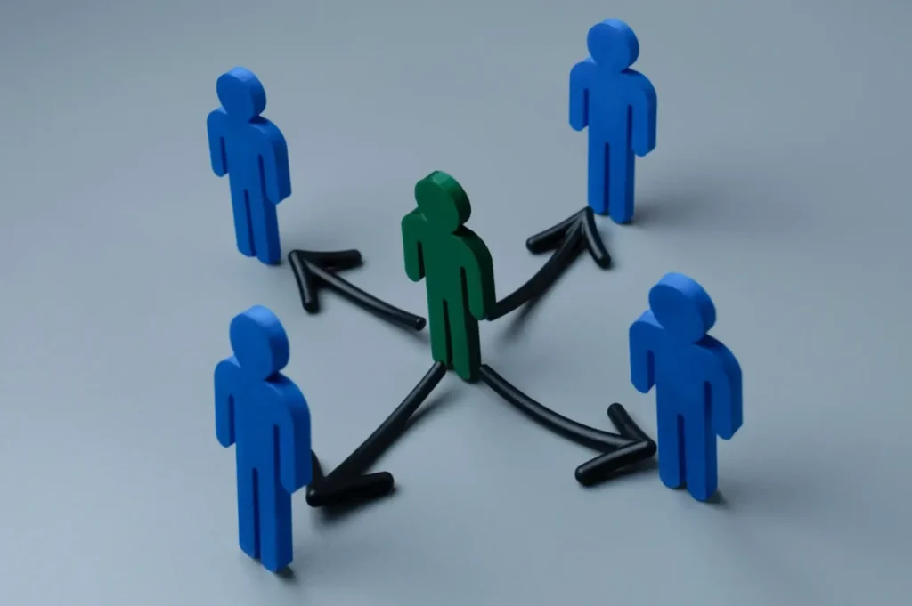 Blue and green wooden figures connected by arrows symbolising teamwork and communication in real estate email marketing services.
